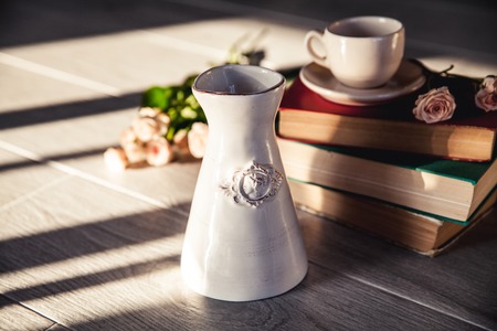 Bouquet of beautiful roses with a cup on the books in vintage styleの写真素材