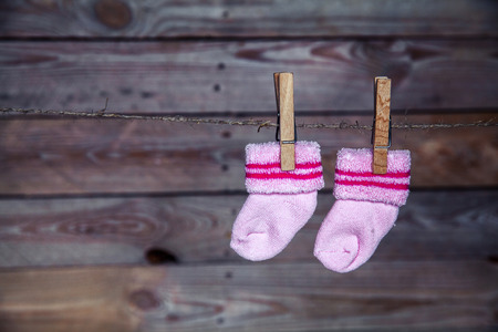 pink socks hang on the clothespin wooden backgroundの写真素材