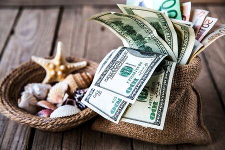 Seashells with money / holiday moneyの写真素材