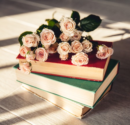 gentle roses with old books on a wooden backgroundの写真素材