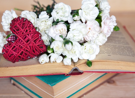 gentle carnation in the old book on a wooden background. Valentine's Dayの写真素材