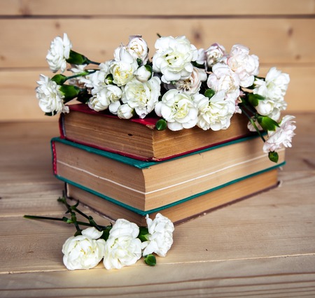 gentle carnation in the old book on a wooden backgroundの写真素材