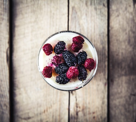 Healthy breakfast - Dairy yogurt with raspberry, mulberry on wooden backgroundの写真素材