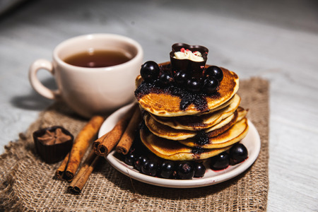 Picture of few pancakes with blackberries and sugar on wooden backgroundの写真素材