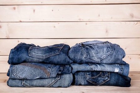 fashionable clothes. pile of jeans on a wooden backgroundの写真素材