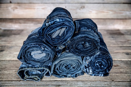 Clothing. twisted jeans on a wooden backgroundの写真素材