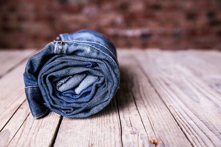 Clothing. twisted jeans on a wooden backgroundの写真素材