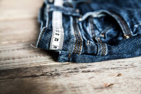 jeans and centimeter on a wooden background. clothingの写真素材