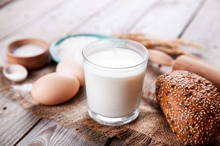 Ingredients for pastry and a glass of milk on wooden background. Food. cookingの写真素材