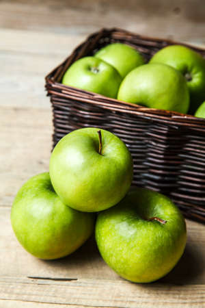 apples in a basket on wooden tableの写真素材