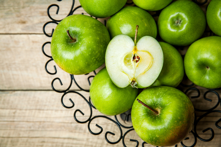 apples in a bowl on wooden backgroundの写真素材