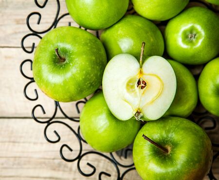 apples in a bowl on wooden backgroundの写真素材