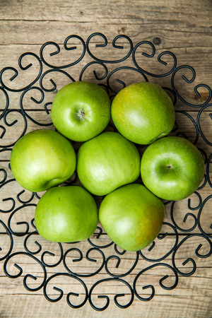 apples in a bowl on wooden backgroundの写真素材