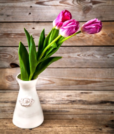 Vase of natural tulips. flowers on a wooden backgroundの写真素材