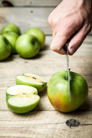 Hands of senior man cutting an appleの写真素材