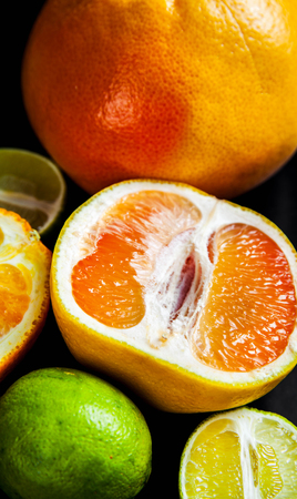 sliced citrus fruit on a black background. foodの写真素材