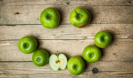 smile. Ripe green apples on wooden backgroundの写真素材