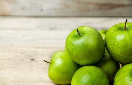 green apples on wooden background