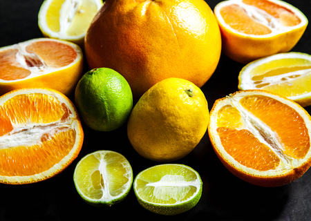sliced citrus fruit on a black background. foodの写真素材