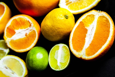 sliced citrus fruit on a black background. foodの写真素材