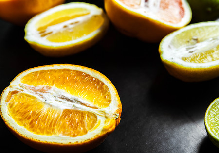 sliced citrus fruit on a black background. foodの写真素材