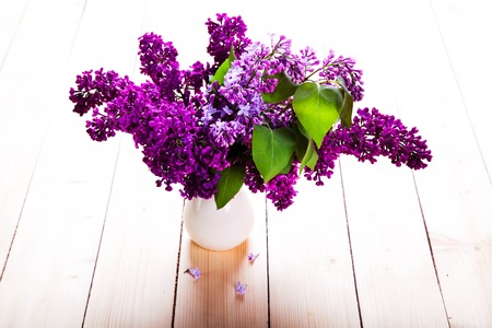 Lilac Bouquet in ceramic jug against a white wooden wall.の写真素材