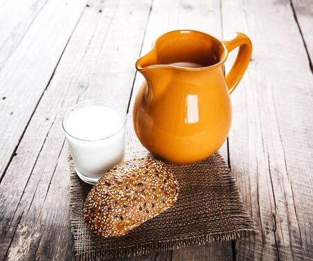 milk and a roll on the wooden backgroundの写真素材