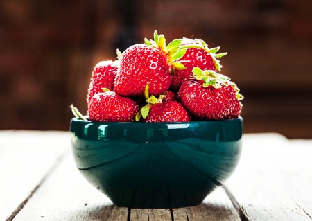 Red strawberries on blue clay plateの写真素材