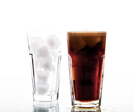 soft drinks. Cola glass with ice cubes over whiteの写真素材