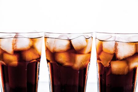 three glasses of cola and ice on a white background. soft drinksの写真素材