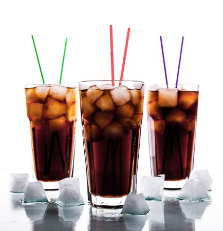 three glasses of cola with ice and straws on a white background. soft drinksの写真素材