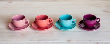 Colorful coffee cups on wooden tableの写真素材