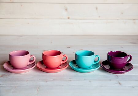 Colorful coffee cups on wooden tableの写真素材