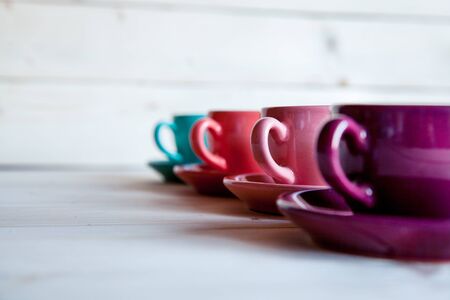 Colorful cups of coffee on wooden tableの写真素材