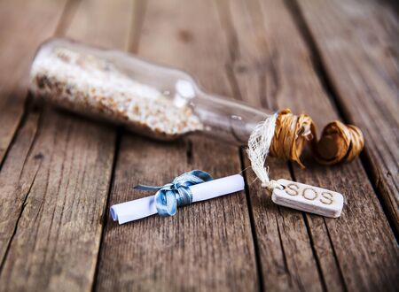 message in a bottle on a wooden backgroundの写真素材