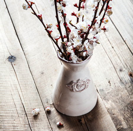 spring blossoms in vintage vase on wooden surfaceの写真素材