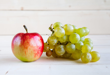 apples with grapes on wooden backgroundの写真素材