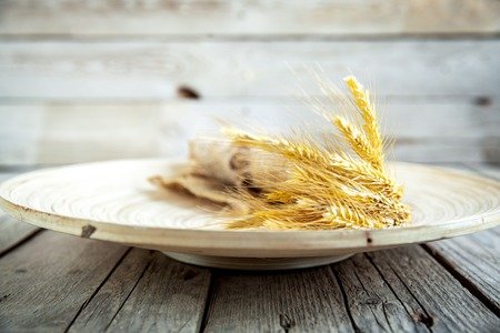 Sheaf on beige plate and wooden backgroundの写真素材