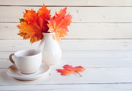 Autumn maple leaves bunch in vase on old wooden backgroundの写真素材