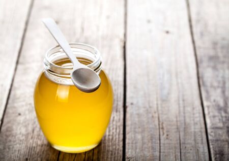 Bowl of honey on wooden table. Symbol of healthy living and natural medicine. Aromatic and tasty.の写真素材
