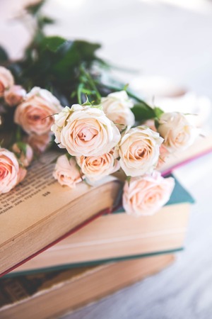 gentle roses with old books on a wooden backgroundの写真素材