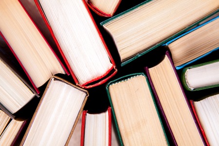 Old and used hardback books or text books seen from above. Books and reading are essential for self improvement, gaining knowledge and success in our careers, business and personal livesの写真素材