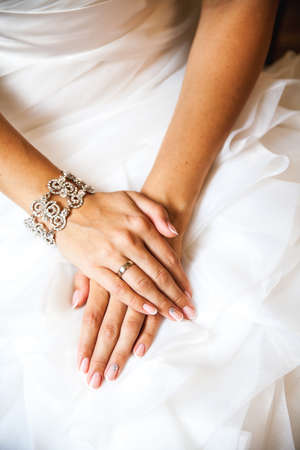 Hands of the bride on a wedding dress. French manicure. Wedding Fashionの写真素材