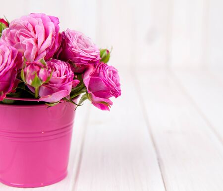 Pink roses(peony) in vase on white wooden background. flowersの写真素材