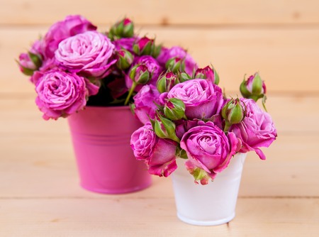 Pink roses in a vase on wooden backgroundの写真素材