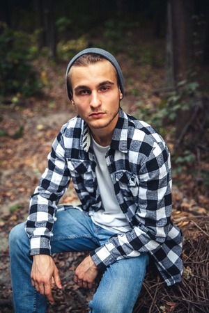 Portrait of young handsome man with backpack wanderer walk in the woods while enjoying the nature...