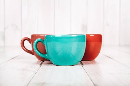 Three color coffee cup on white wooden backgroundの写真素材