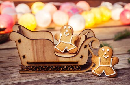 Christmas food. Gingerbread man. Garland. Santa's sleigh on a wooden backgroundの写真素材