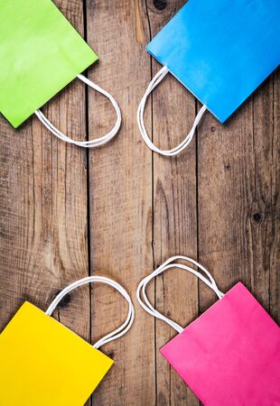 multicolored Shopping bags on a wooden background, sale, purchaseの写真素材