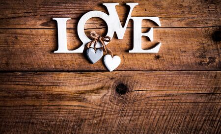 Wooden letters forming word LOVE written on wooden background. St. Valentine's Day. two heartsの写真素材